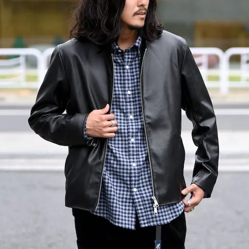 黒のレザージャケットにチェックのシャツを合わせた男性